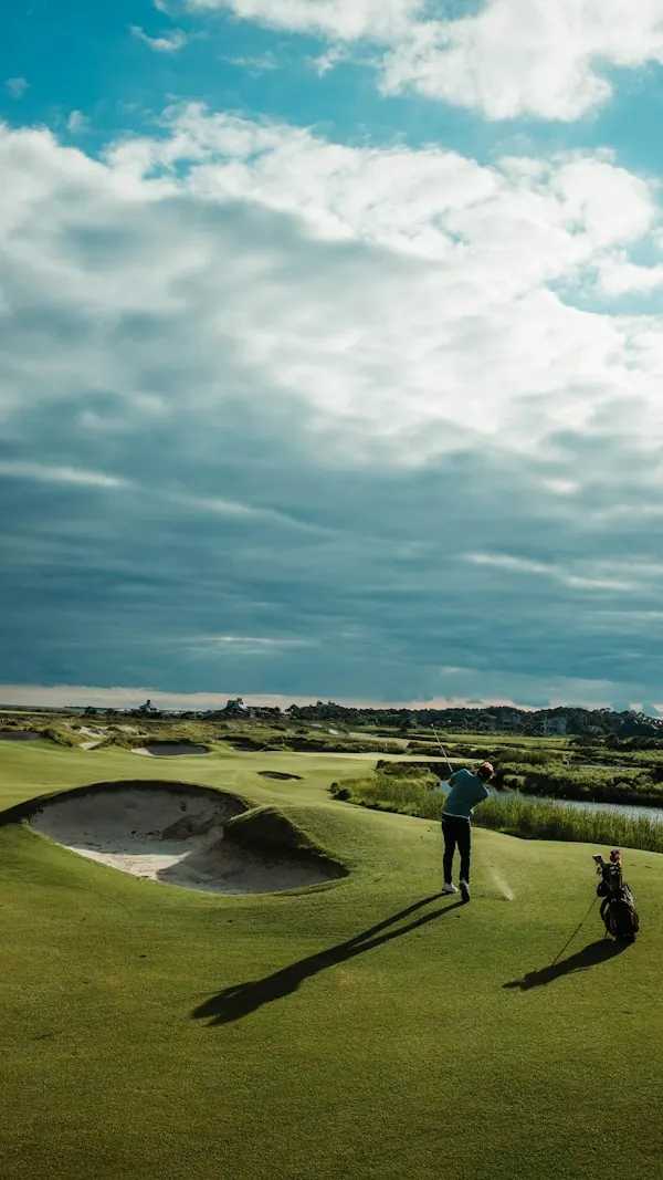 Golfers on a links course under a cloudy sky