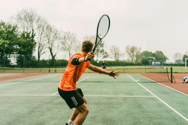 Tennis player hitting a forehand on a grass court