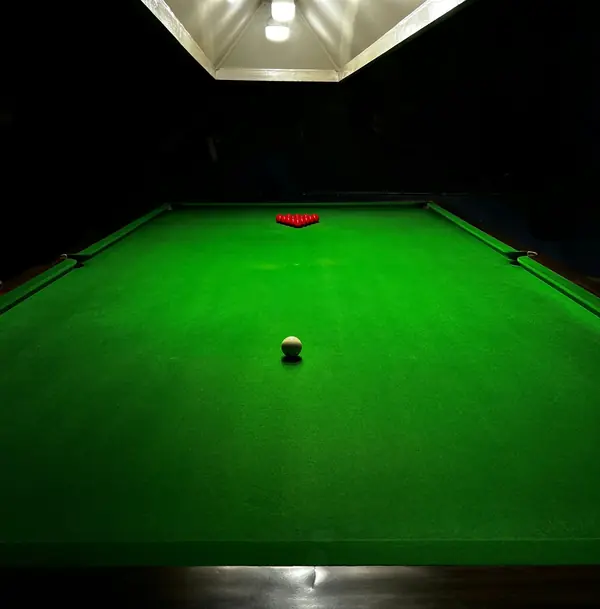 A snooker table under a lamp